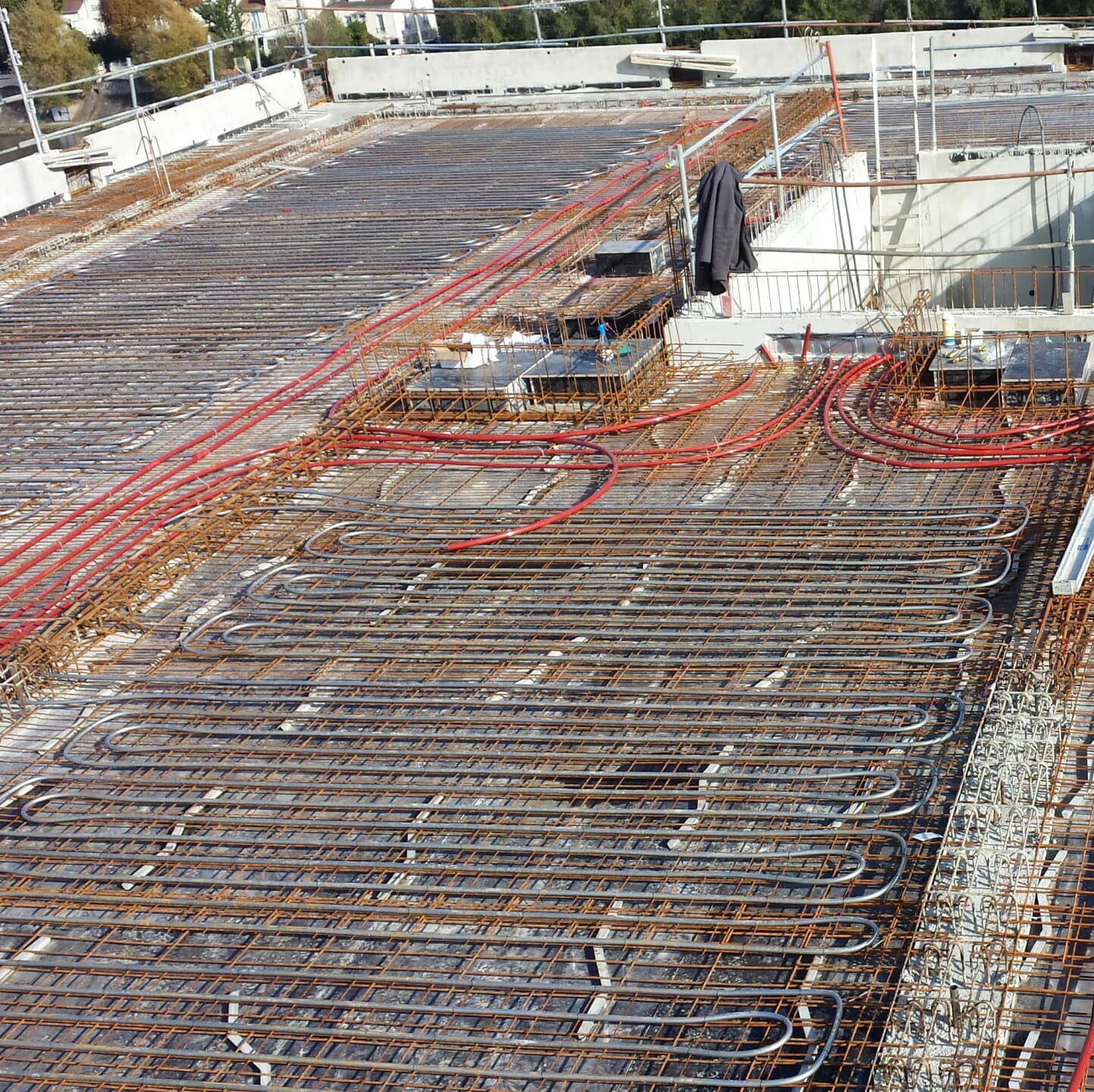 Tubes de plancher chauffant posés sur une grande dalle avant le coulage